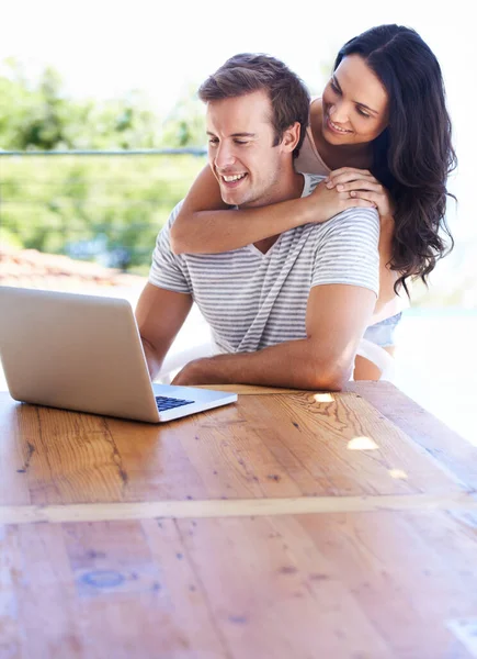 A navegar na Internet lá fora. Um jovem casal usando seu laptop no pátio. — Fotografia de Stock