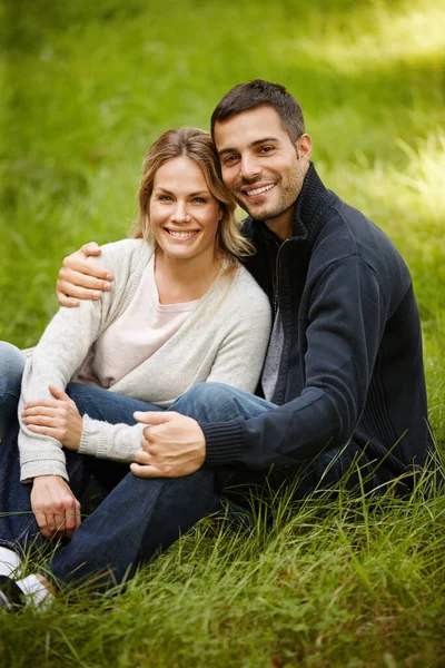 Parkeer romantiek. Portret van een liefdevol jong koppel zittend op het gras in een park. — Stockfoto