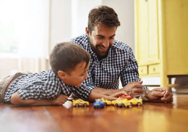 No cambiaría el tiempo con su hijo por nada. Un disparo de un niño y su padre jugando con coches en el suelo. — Foto de Stock