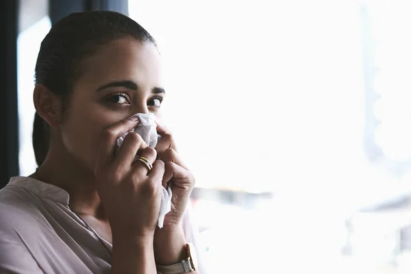 Chegou a época das alergias. Retrato de uma jovem empresária soprando o nariz em um escritório. — Fotografia de Stock