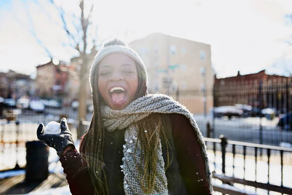 Πρώτος κανόνας του χειμώνα, να έχεις χιονοπόλεμο. Πυροβόλησε μια όμορφη νεαρή γυναίκα ρίχνοντας μια χιονόμπαλα σε μια χειμωνιάτικη μέρα στην ύπαιθρο. — Φωτογραφία Αρχείου