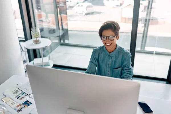 Las personas con gran pasión pueden hacer que lo imposible suceda. Recortado disparo de una atractiva joven empresaria sentada sola y trabajando en su computadora en la oficina. — Foto de Stock