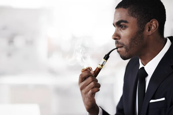 Vapeando con estilo. Un joven empresario fumando una pipa electrónica en una oficina. —  Fotos de Stock