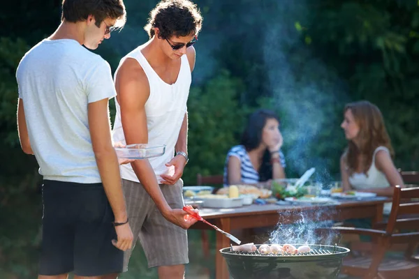 Grillowanie mięsa do perfekcji. Młodzi faceci grillujący mięso na grillu na świeżym powietrzu - Styl życia. — Zdjęcie stockowe