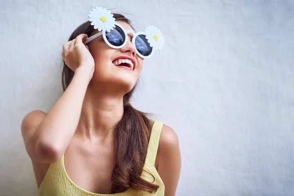 Wherever she goes the sun goes. Studio shot of a cheerful young woman wearing sunglasses while posing against a grey background. — Stock Photo, Image