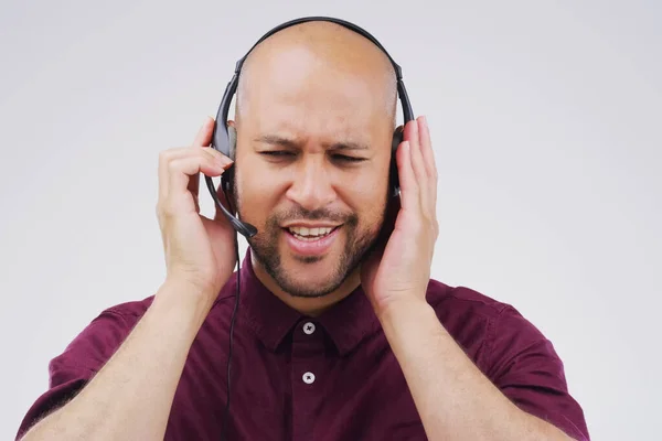 Una respuesta eficiente es en lo que se basan las excelentes relaciones con los clientes. Imagen de estudio de un apuesto joven representante de servicio al cliente con un auricular sobre un fondo gris. — Foto de Stock