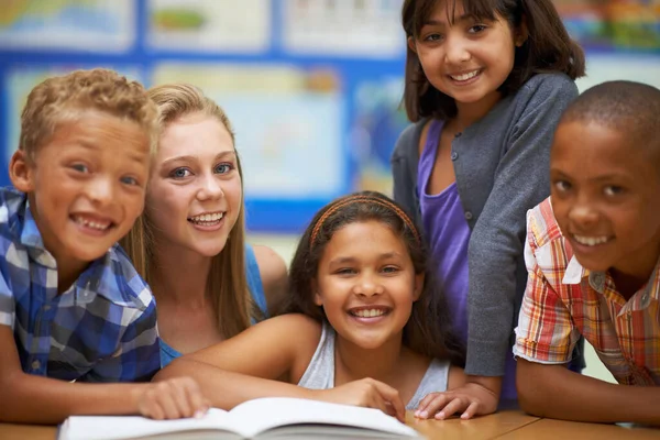 Apprendre à lire et l'aimer. Portrait d'un groupe d'élèves lisant un livre en classe. — Photo