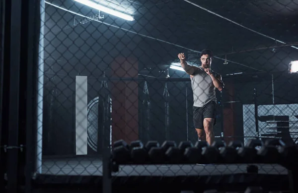 Je zag hier eerst de kickbokslegende. Shot van een jonge man oefenen zijn kickboxing routine in een sportschool. — Stockfoto