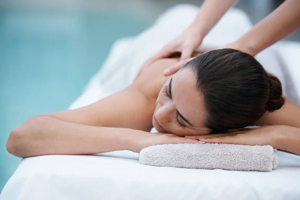 Perder-se no conforto sublime. Tiro de uma mulher desfrutando de uma massagem ao lado de uma piscina. — Fotografia de Stock