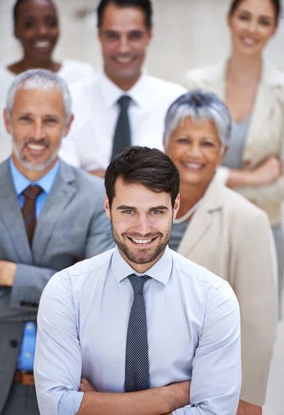 ¿Por qué conformarse con mediocre cuando se puede tener increíble. Retrato de un hombre de negocios sonriente rodeado por un grupo de sus colegas. — Foto de Stock