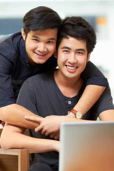 Zadowoleni z bycia razem. Portret czułej młodej pary gejów relaksującej się w domu z laptopem. — Zdjęcie stockowe