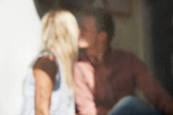 Χαμένος στην αγάπη. Θολή εικόνα μέσα από ένα παράθυρο καφενείου όπου ένα νεαρό ζευγάρι φιλιέται. — Φωτογραφία Αρχείου