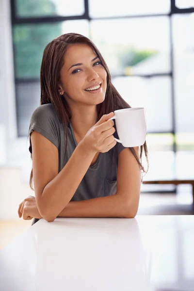 Relaxando com uma xícara de java. Tiro de uma jovem atraente bebendo um café em casa. — Fotografia de Stock