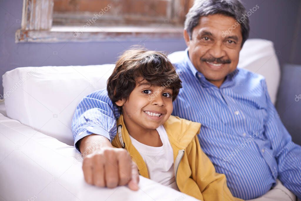 Im so proud of my grandson. Portrait of a smiling grandfather and grandson sitting on a sofa at home.