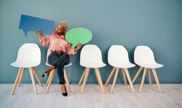 Co to říkáš, drahá? Studio záběr atraktivní mladé podnikatelky drží řeč bubliny, zatímco sedí v řadě na šedém pozadí. — Stock fotografie