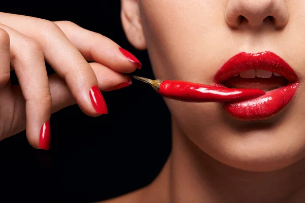 O outro fruto proibido. Fechar-se de uma mulher segurando um chili vermelho na boca. — Fotografia de Stock