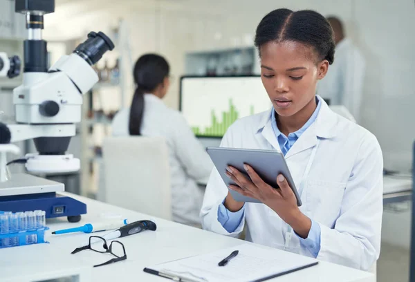 Teilen Sie alle ihre Daten in einem Augenblick. Aufnahme eines jungen Wissenschaftlers mit einem digitalen Tablet im Labor. — Stockfoto