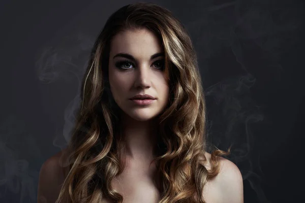 Enkelt och vackert. En vacker ung kvinna poserar i studioStudio koncept skott av en vacker ung kvinna med rök kommer från hennes. — Stockfoto