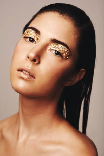 Все це блищить. Портрет привабливої брюнетки з золотими пластівцями навколо її очей . — стокове фото
