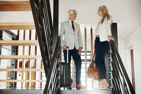 O lugar parece ótimo até agora. Tiro de dois empresários confiantes descendo escadas juntos enquanto conversavam dentro de um prédio durante o dia. — Fotografia de Stock