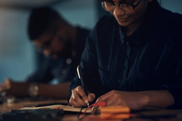 Nunca es demasiado tarde para reacondicionar el hardware de su computadora. Fotografía de un joven técnico escribiendo en un cuaderno mientras reparaba el hardware de la computadora. — Foto de Stock