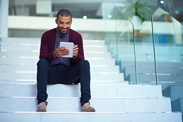 Tecnologia alimenta a inovação. Tiro de um jovem empresário usando um tablet digital nas escadas em um escritório moderno. — Fotografia de Stock