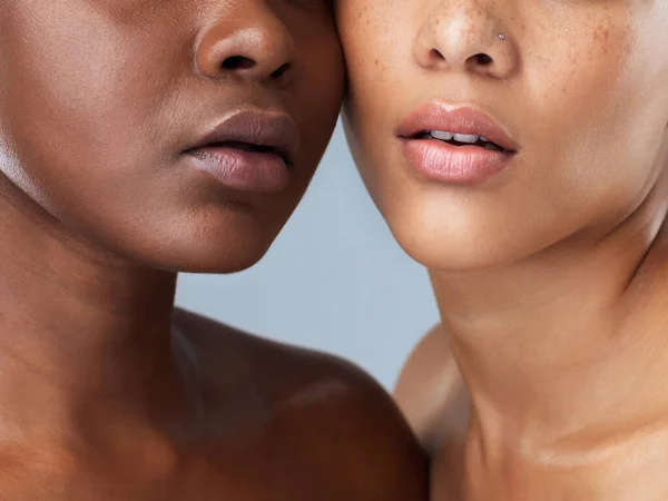 Vi är ett. Porträtt av två oigenkännliga unga kvinnor som står nära varandra mot en grå bakgrund. — Stockfoto