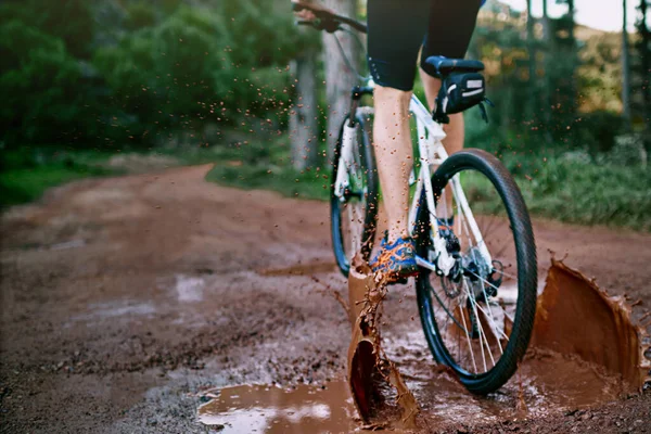 Mit Strom durch den Schlamm. Schnappschuss eines männlichen Radfahrers, der auf einem schlammigen Mountainbike-Weg unterwegs ist. — Stockfoto