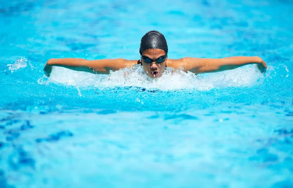 Schlaganfall für Schlaganfall. Eine fokussierte junge Schwimmerin beim Schmetterlingsschlag. — Stockfoto