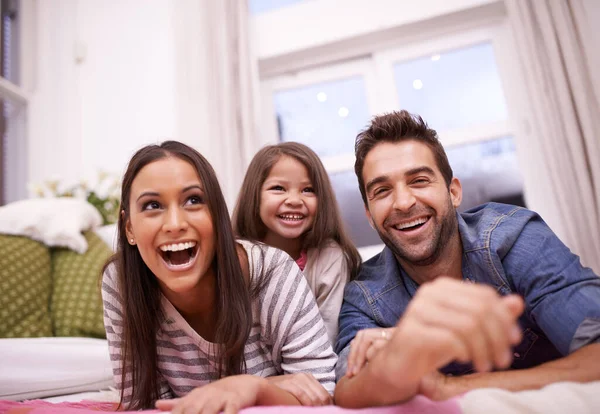 Kärlek och skratt hemma. Porträtt av en lycklig ung familj hemma. — Stockfoto