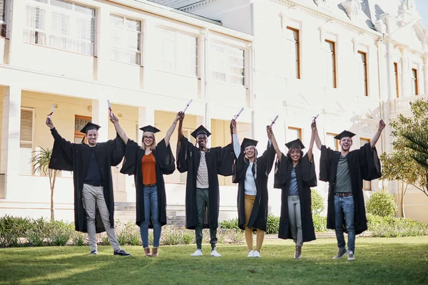 Es ist unser Ticket zum Erfolg. Porträt einer Gruppe von Studenten, die am Abschlusstag mit erhobenen Armen in einer Schlange stehen. — Stockfoto