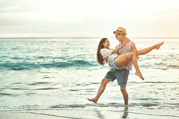 Я никогда тебя не отпущу. Полнометражный снимок любящей молодой пары, наслаждающейся отдыхом на пляже. — стоковое фото