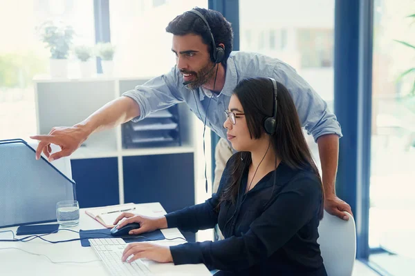 Een nieuwe medewerker opleiden over het leveren van kwaliteitsservice. Gesneden opname van twee call center agenten die samenwerken in een kantoor. — Stockfoto