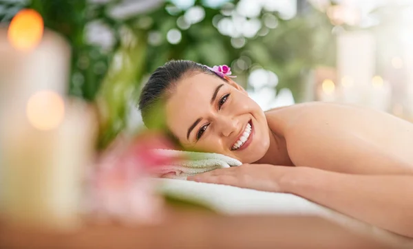 Das Paradies liegt hier direkt am Thermalbad. Porträt einer attraktiven jungen Frau, die es sich auf einem Massagetisch in einem Wellnessbereich gemütlich macht. — Stockfoto