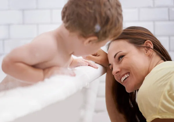 Mi assicuro che il suo bambino sia fresco e pulito. Un bambino che si lava nel bagno sotto la supervisione di sua madre. — Foto Stock