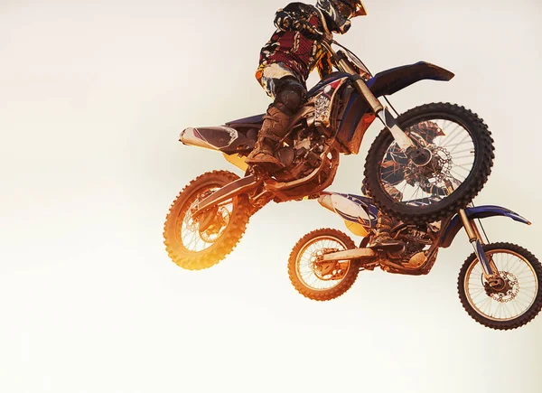 Sie liefern sich ein Kopf-an-Kopf-Rennen. Ein Schuss von zwei Motocross-Fahrern in Middair während eines Rennens. — Stockfoto