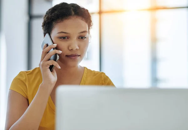 Verbinden met nieuwe kansen. Shot van een jonge ontwerper praten op een mobiele telefoon tijdens het werken op een laptop in een kantoor. — Stockfoto