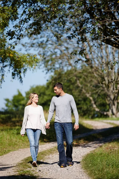 Het is een perfecte dag voor liefde. Volledige opname van een jong koppel dat hand in hand in een park loopt. — Stockfoto