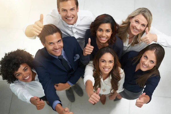 Lo estás haciendo muy bien. Retrato de un grupo de empresarios mostrando pulgares juntos en una oficina. — Foto de Stock