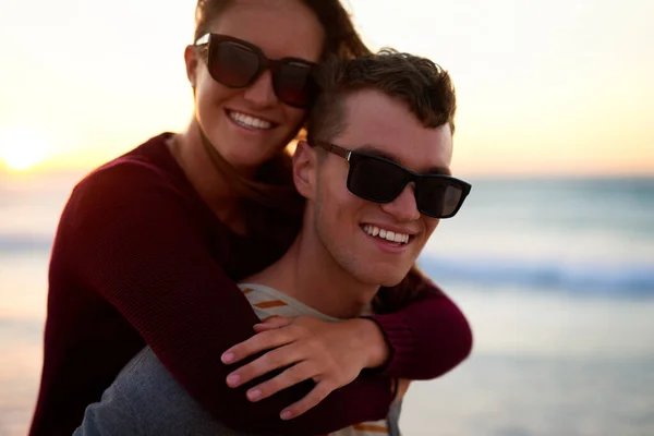 La felicidad es una palabra de cuatro letras. Retrato recortado de un joven cariñoso que apoya a su novia en la playa. — Foto de Stock