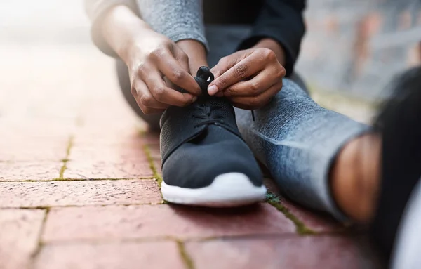 Dags att röra på sig. Beskuren bild av en kvinna som knyter skosnörena före träningspasset. — Stockfoto