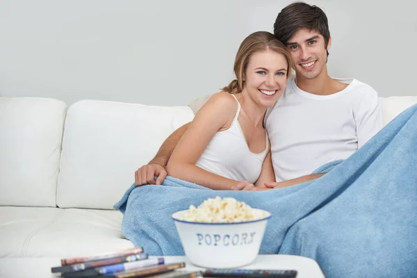 Prêt à être diverti. Un jeune couple regardant un film à la maison. — Photo