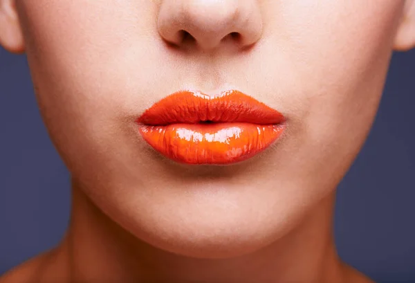 Sólo un toque de mandarina. La foto recortada de una mujer labios cubiertos de lápiz labial naranja brillante. —  Fotos de Stock