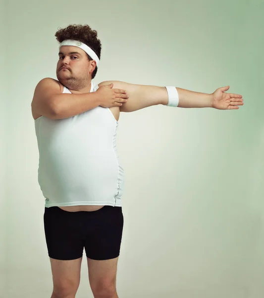 Alongamento é importante. Homem com excesso de peso fazendo alongamentos de braço. — Fotografia de Stock