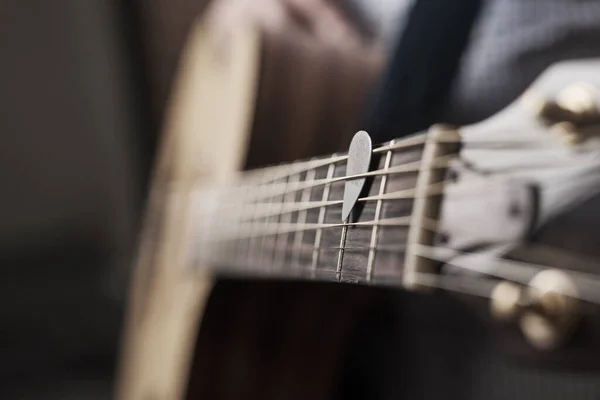 Apanha a música. Tiro cortado de um homem irreconhecível tocando uma guitarra acústica em casa. — Fotografia de Stock