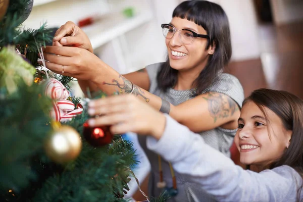 Kedvenc karácsonyi hagyományok. Egy anya és lánya felakasztotta a karácsonyi díszeket egy fára.. — Stock Fotó