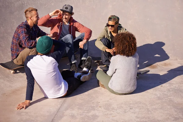 友達と楽しい時間を。スケートパークで太陽の下で座っている友人のグループのショット. — ストック写真