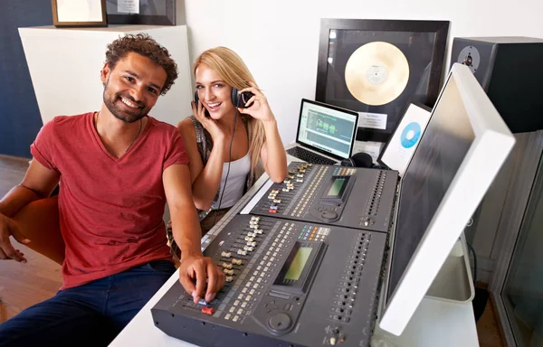 Pronto para tomar a indústria fonográfica de assalto. Dois jovens engenheiros de som sentados em seu estúdio de gravação sorrindo para a câmera. — Fotografia de Stock