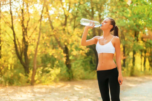 Nur... eine kurze... Pause. Aufnahme einer Frau, die beim Joggen im Park Wasser trinkt. — Stockfoto