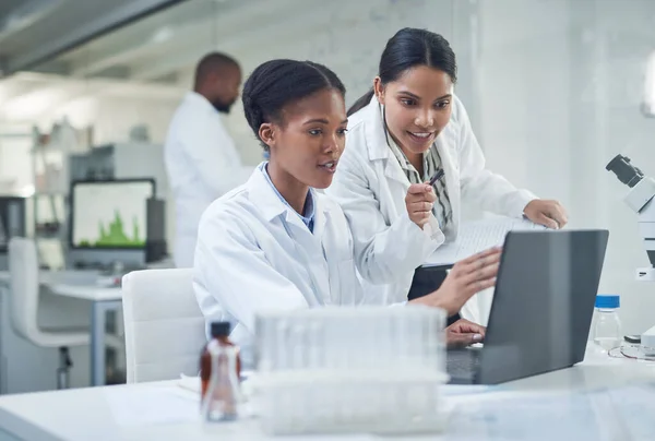 Eine Zusammenarbeit nach der anderen verbessert das Leben. Aufnahme zweier junger Wissenschaftler mit einem Laptop in einem Labor. — Stockfoto